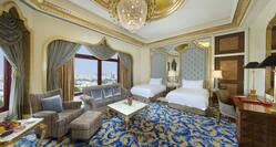 Qasr Room with two queen beds, lounge area, and outside view