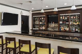  Fully Stocked Hotel Bar With Counter Seating and TV
