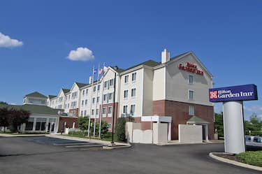 Angled View of Hotel Exterior, Signage, Flagpoles, Landscaping, and Parking Lot