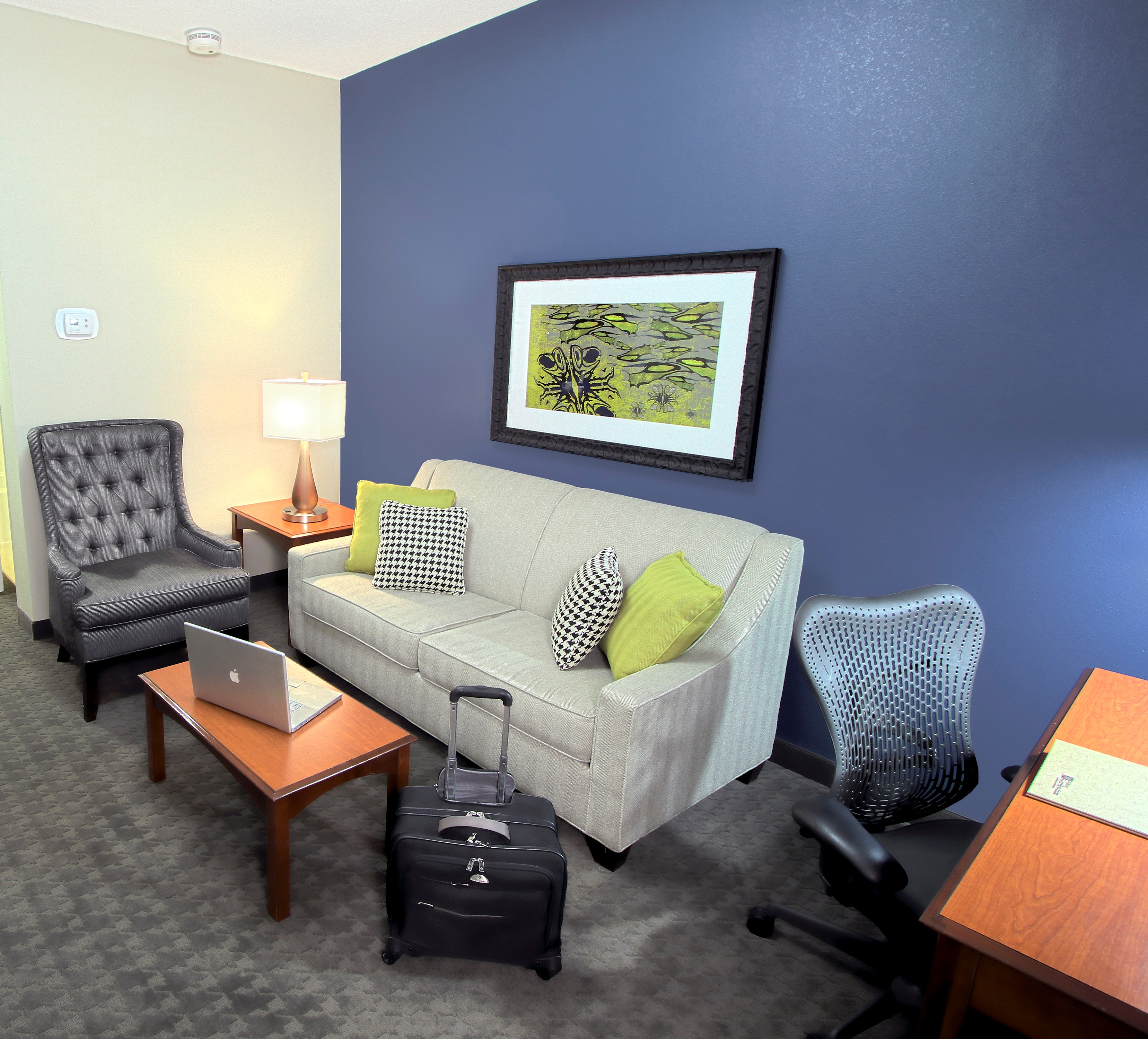 Suite Living Area With Wall Art, Table, Soft Seating, and Work Desk