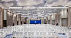 Ballroom Arranged Theater Style With Rows of White Chairs Facing Projector Screen