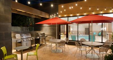 Outdoor Patio with Chairs, Tables, Umbrellas and Grills