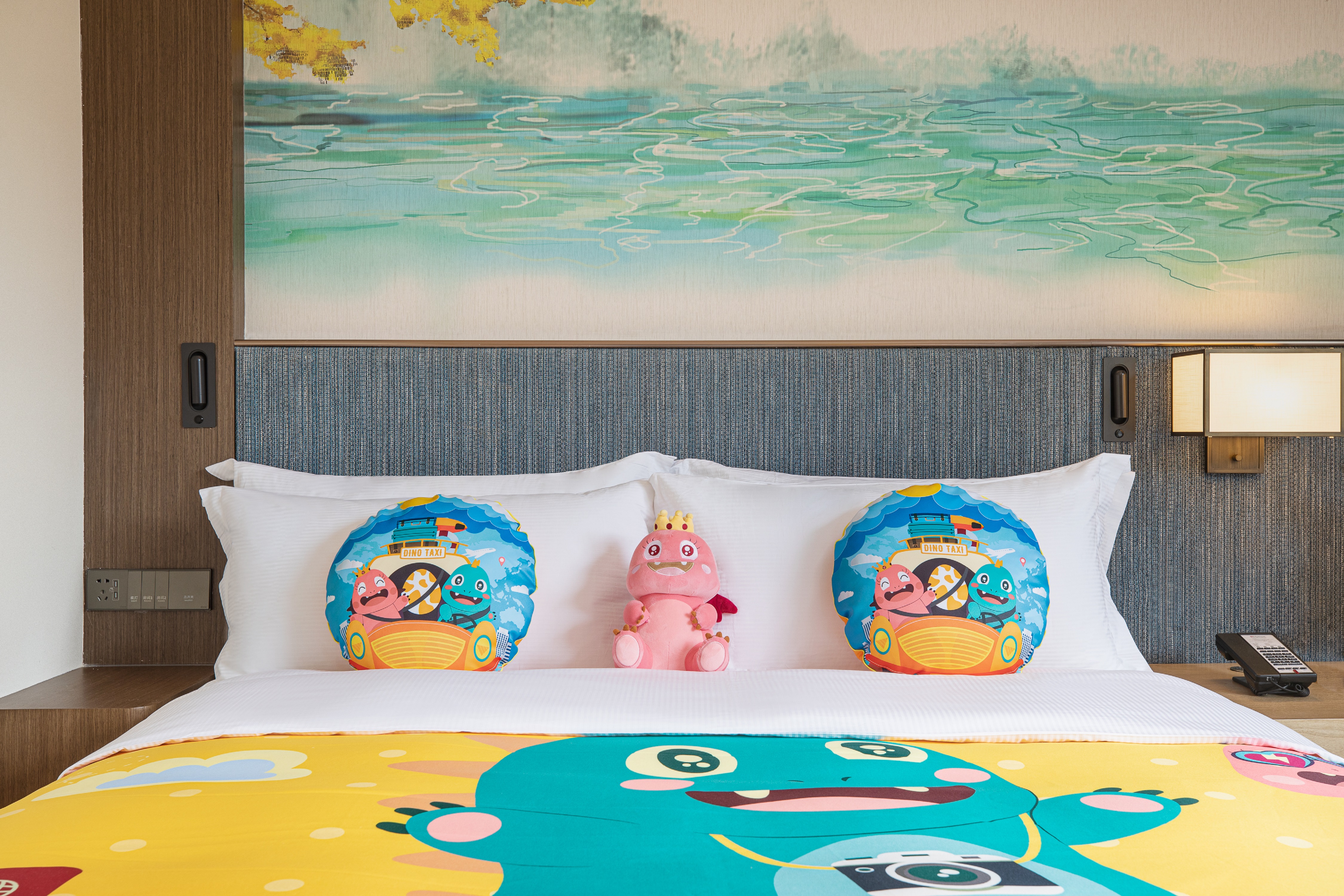 Bed in room with toys and cartoons on duvet