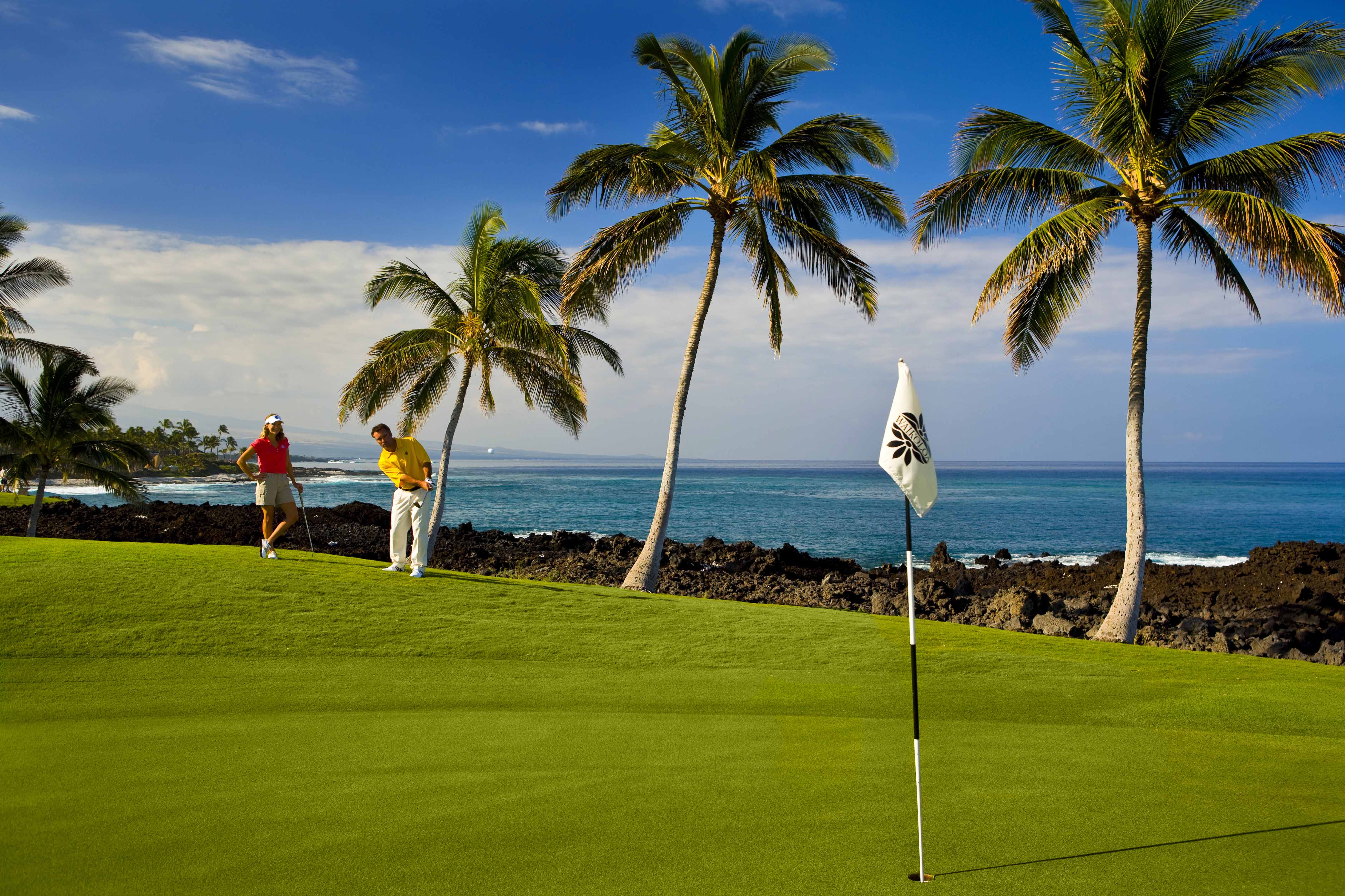 Man and Woman Golfing Next to Beach