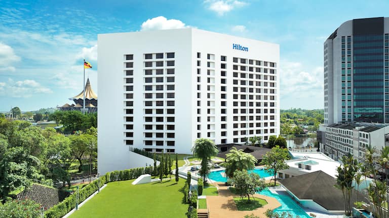 Aerial view of exterior of building with outdoor pool and water features.