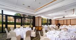 Spacious Ballroom Dining Area with Roundtables and Chairs 