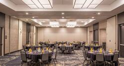 Ballroom With Chairs and Round Banquet Tables With Place Settings and Centerpieces