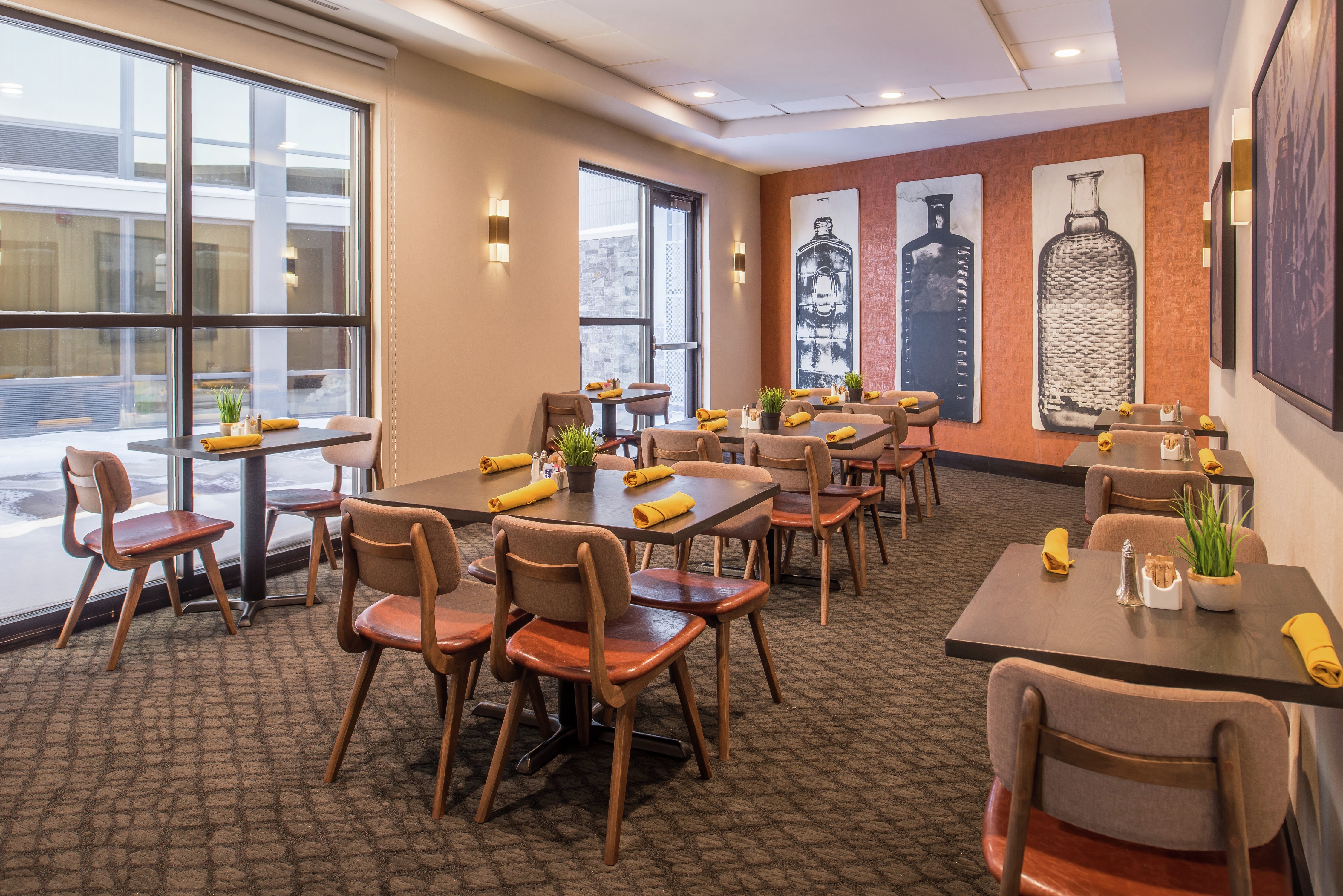 Private Dining Room in Made Market Restaurant With Large Windows, Wall Art, Tables, and Chairs
