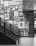 Stairs with lots of framed artwork on wall