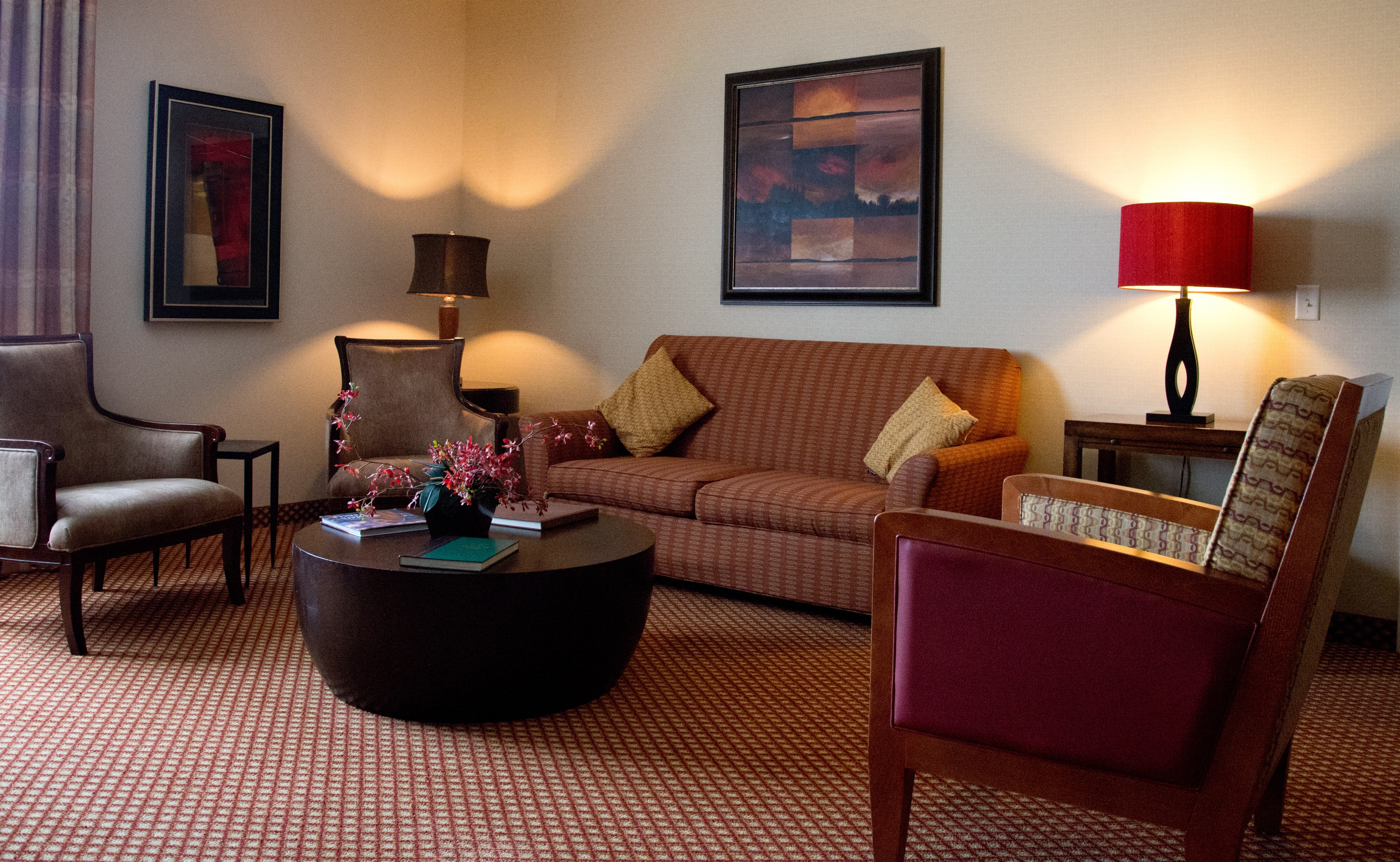 Executive Suite Living Area With Arm Chairs, Sofa, Wall Art, Lamps and Round Coffee Table