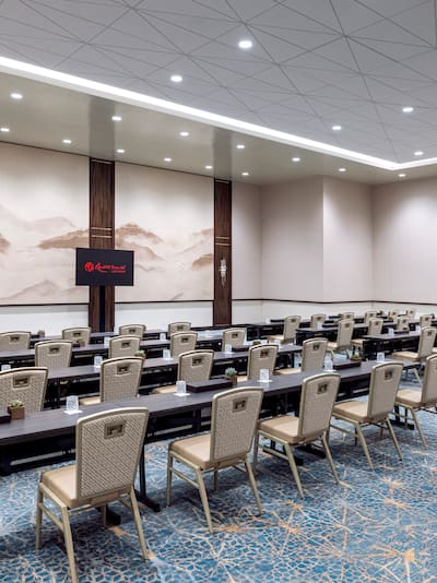 meeting room with rows of tables and chairs setup for a conference