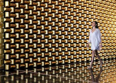 Gold Wall with Woman Walking in Front on the 23rd Floor