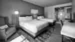 Two queen beds with work desk in guest room