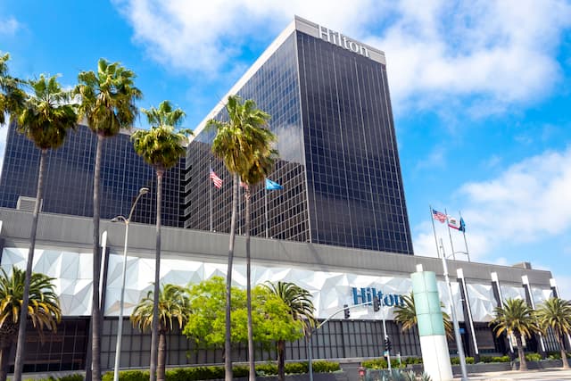 Hotel exterior with palm trees and flags