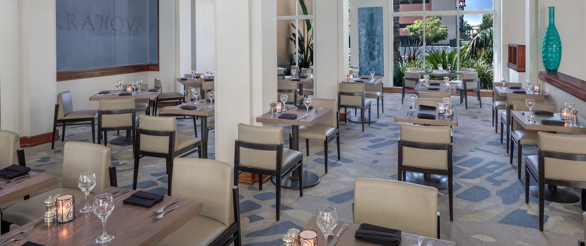 TerraNova Restaurant Dining Area with dining table, chairs, and floor-to-ceiling windows with an outdoor view