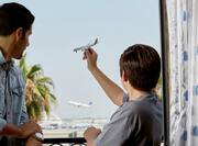 Father and Son at Hotel Balcony Watching Plane Takeoff