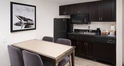 Suite with Full Kitchen That Includes a Microwave, Refigerator, Sink, and Dining Table With Seating For Four, 