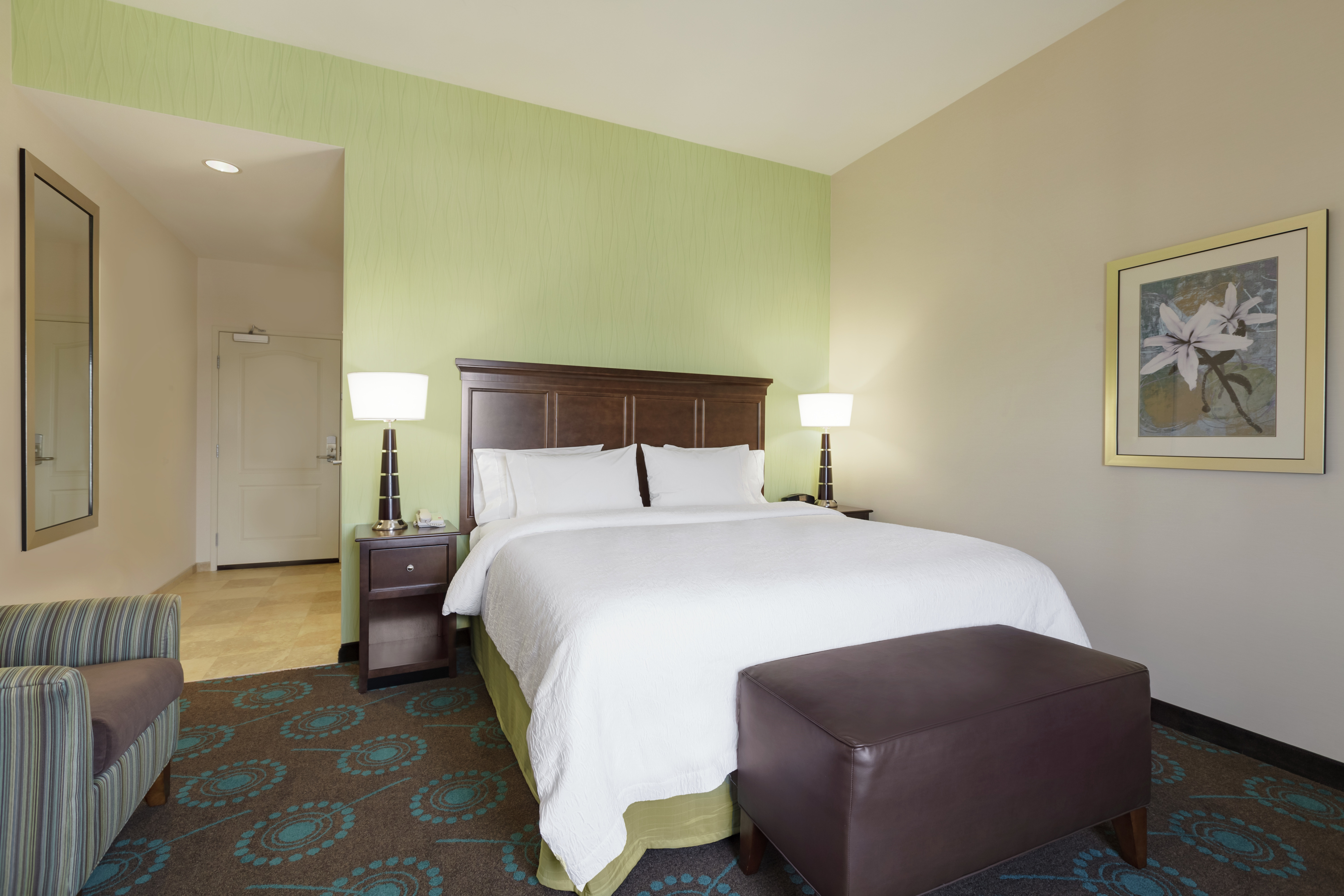 Bright guestroom featuring comfortable king bed and welcoming decor.