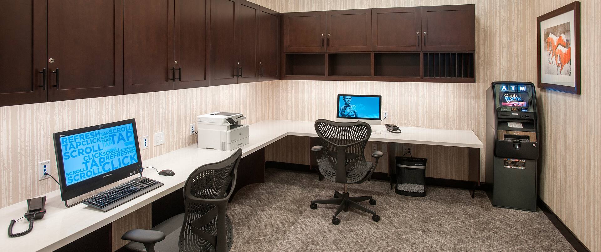Business Center With Overhead Cabinets, Two Computer Workstations, Ergonomic Chairs, Printer/Fax/Copier, and ATM Machine in corner by Wall Art