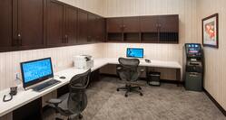 Business Center With Overhead Cabinets, Two Computer Workstations, Ergonomic Chairs, Printer/Fax/Copier, and ATM Machine in corner by Wall Art