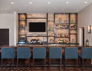 Fully Stocked Lobby Bar With Counter Seating, and TV