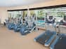 Fitness Center with Free Weights in Corner and Cardio Equipment Facing Windows With a View of the Outdoor Pool