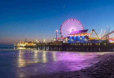 Night time view of Santa Monica pier with illuminatied ferris wheel and attractions