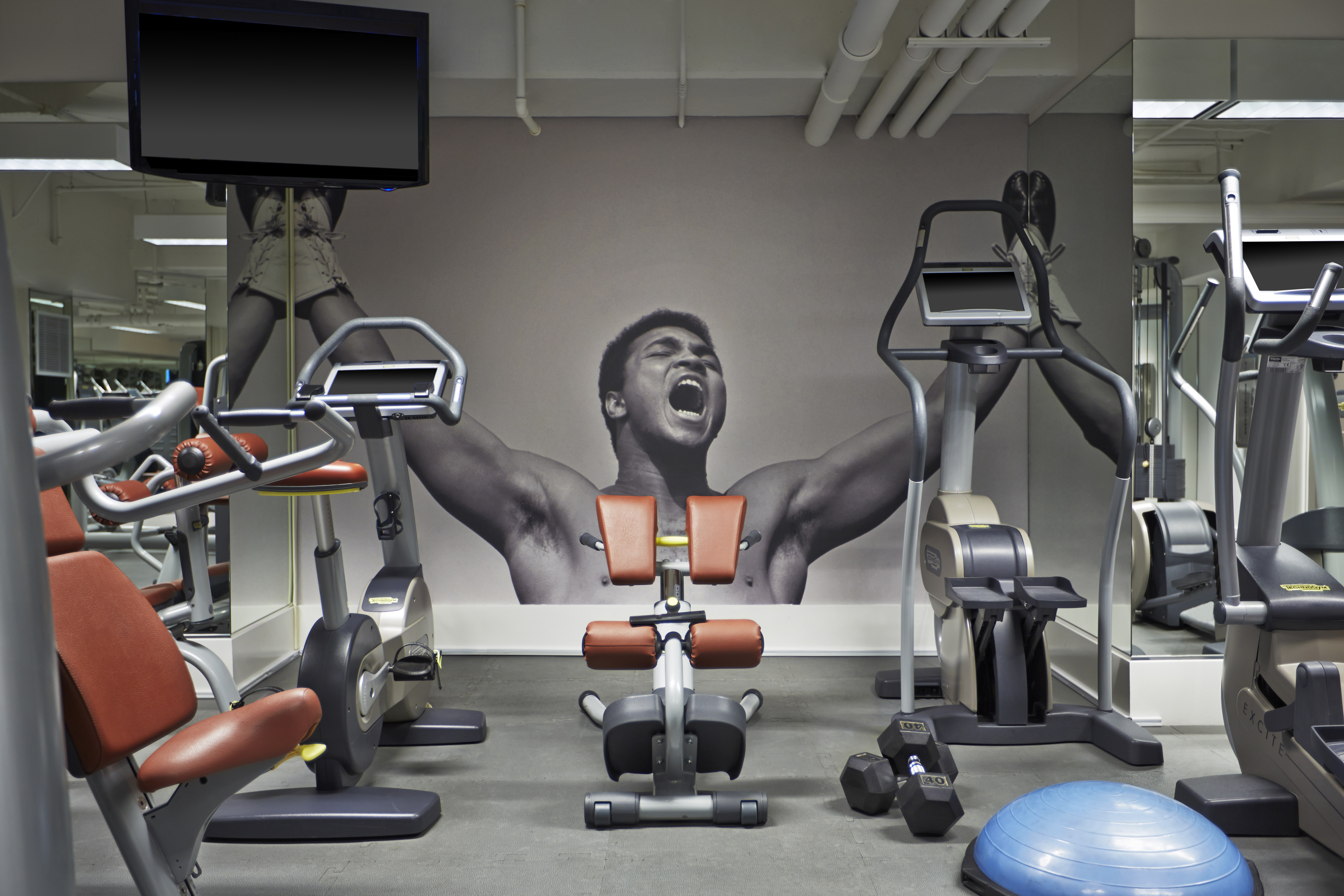 Fitness center with cardio machines, bench and TV