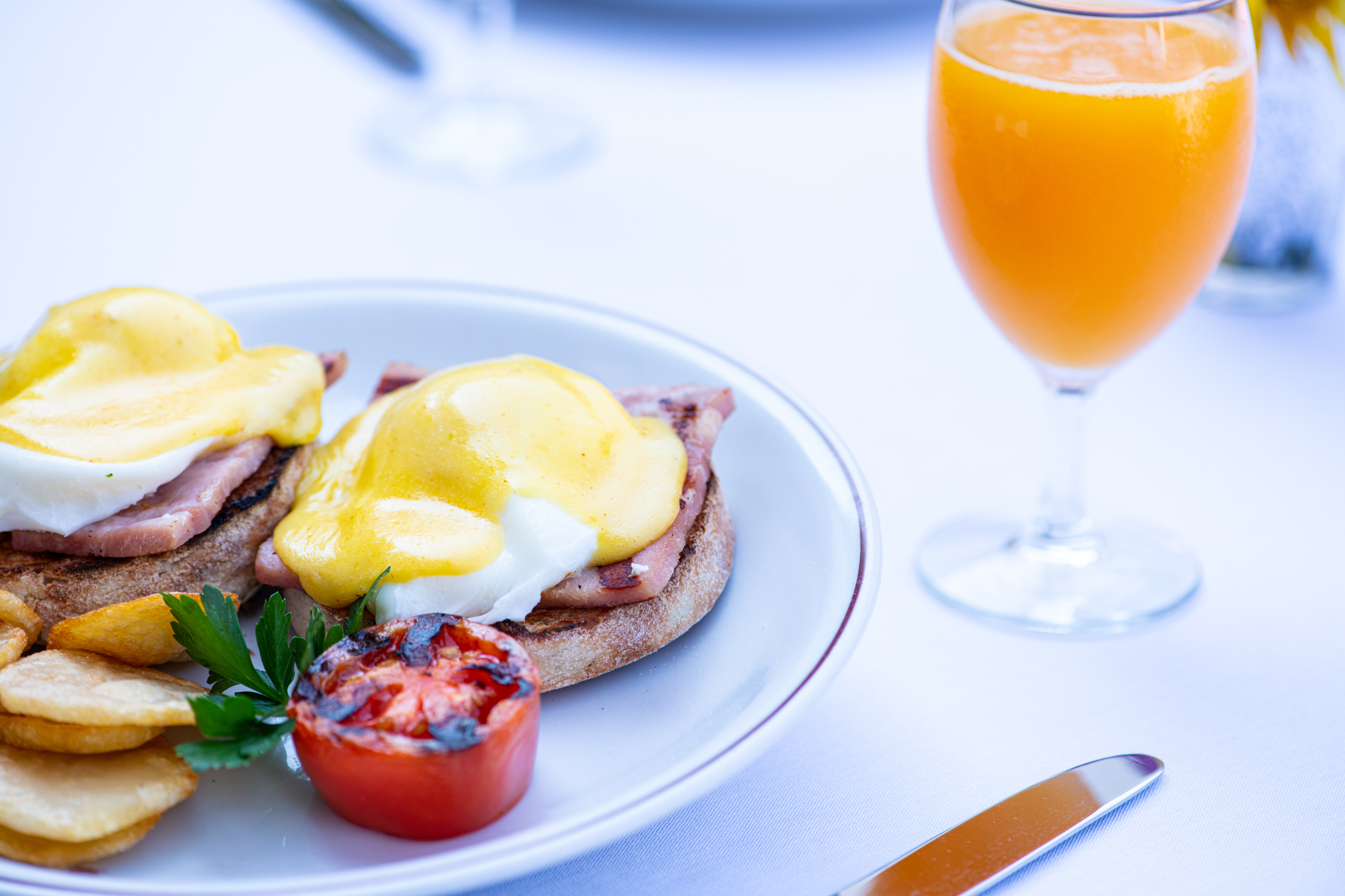 Breakfast foods on plate with orange juice