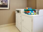 Guest Laundry With Wall Art, Washer, and Detergent With Towels on Dryer 