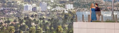 Mann und Frau auf Balkon mit Blick auf die Beverly Hills
