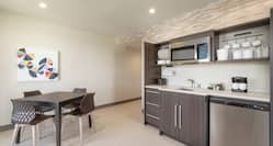 Bright living area in suite featuring fully equipped kitchen and dining table.