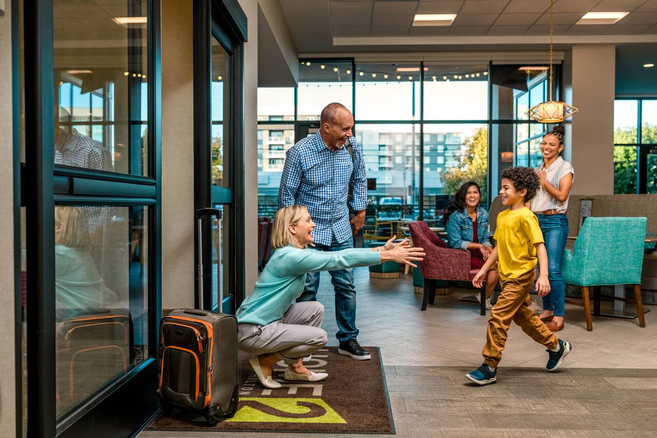 Happy family greeting each other in modern lobby