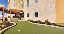  On-Site Putting Green With Two Holes and Landscaping by Building Exterior