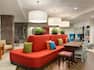 Oasis Lobby Area With Large Red Sofa, Armchairs Decorative Lighting and Table by Windows