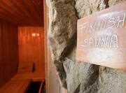 "Finnish Sauna" Sign on Rock Wall Outside of Wooden Seating in Sauna