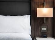 Details of King Bed, Illuminated Lamp Above Bedside Table in Accessible Room
