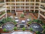 overview of hotel atrium, dining tables, water fountains