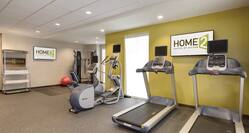 Towel Station, TVs, Red Exercise Ball, Weight Machine in Corner, Elliptical and Treadmills in Spin2 Cycle Fitness Center 