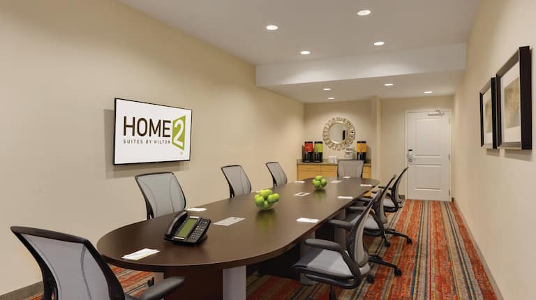 Boardroom Table With Seating for 8, TV, Beverage Station, and Wall Art in Conference Room