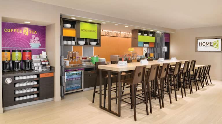 Hot Beverage Station, Hot and Cold Breakfast Options in Food Service Area With TV and Counter Seating