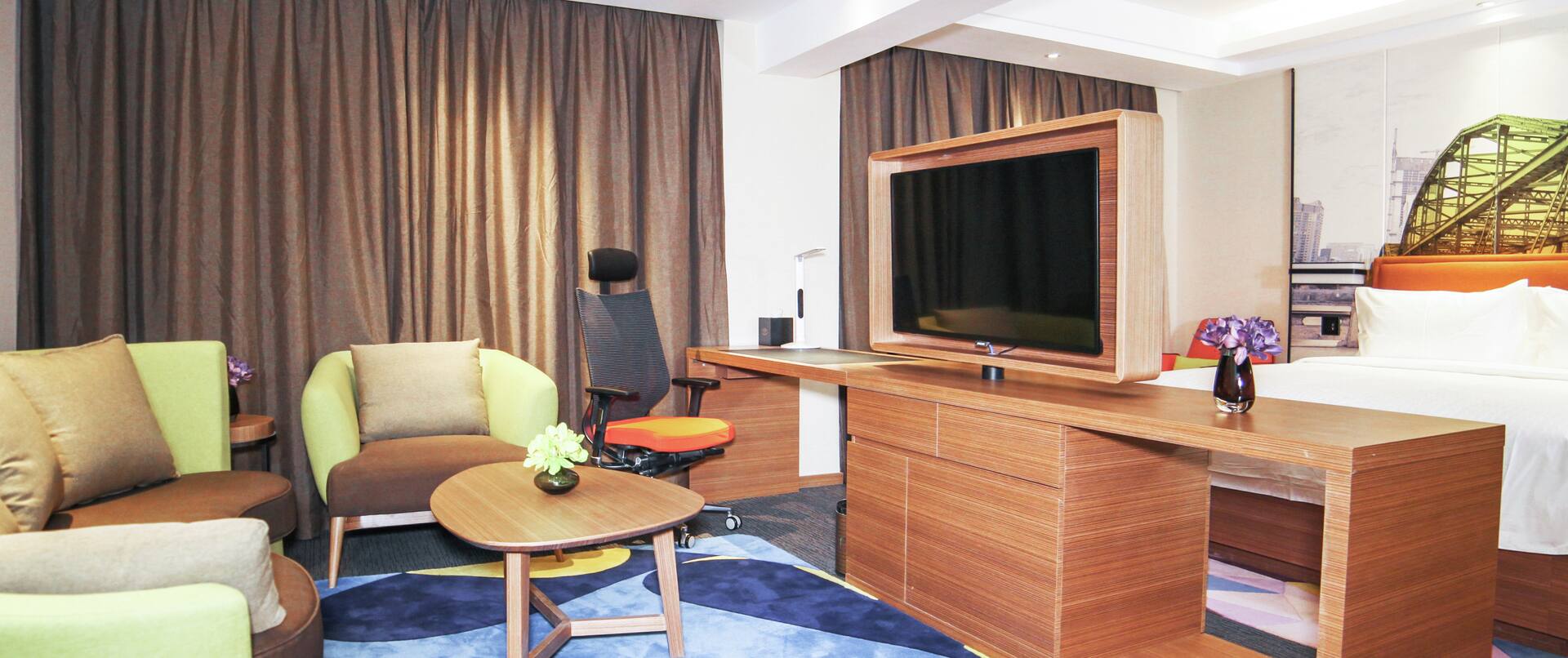 King Bed, Lounge Seating, Work Desk, and Flat Screen TV in Business Suite