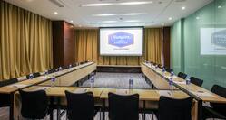 U-Shaped Table and Chairs Setup in Meeting Room with Projector Screen