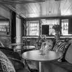 منطقة جلوس في البار بها مقاعد للجلوس، وطاولات، ومقاعد