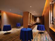 Panoramic View of Meeting Foyer with View of Door, Registration Table, Food and Beverage Service Tables