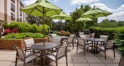 Outdoor patio with Four Umbrella Tables that Each Seat Four