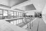 indoor pool area with seating around and view of the outside to patio area