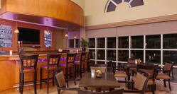 Lounge Bar With TV, Counter Bar Stools, and Table Seating by Large Windows