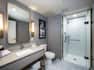 King deluxe bathroom with shower, sink and vanity mirror