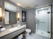 King deluxe bathroom with shower, sink and vanity mirror